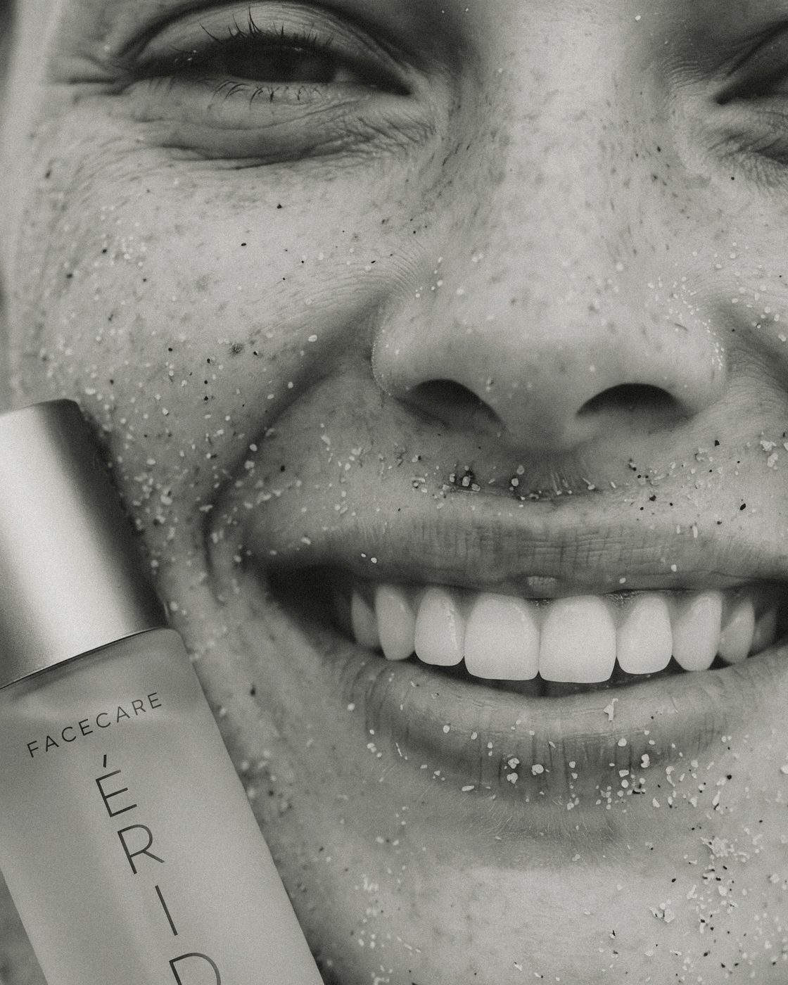 Nasmejano lice sa kapljicama vode i ÉRIDAN Collagen Face Mist bočica