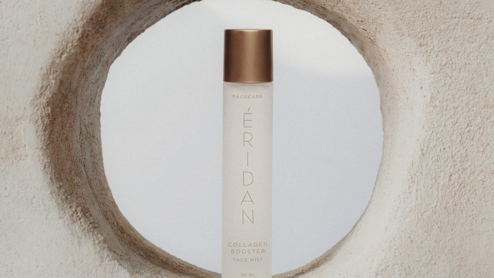 ÉRIDAN Collagen Face Mist bočica u kamenom otvoru sa pogledom na nebo