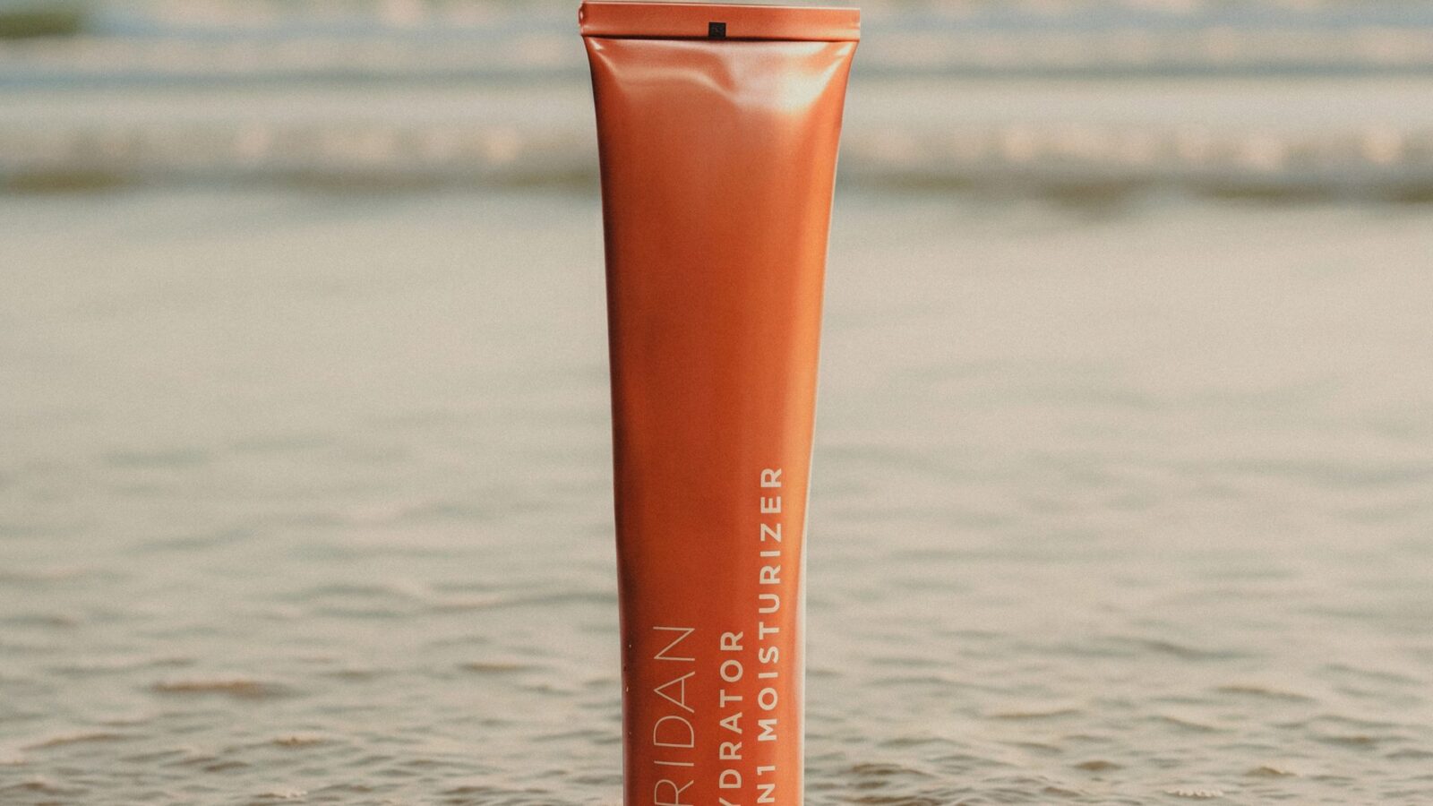 ÉRIDAN Hydrator 3in1 Moisturizer tuba stoji na obali dok se talas povlači